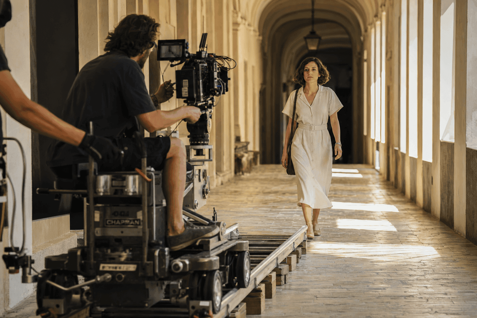 Cinematographer filming a tracking shot of a person on a professional film set